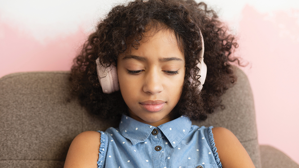 a student wearing headphones looks down