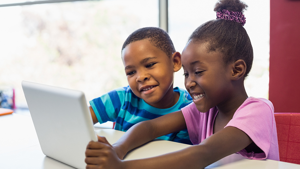 a boy and a girl happily use a laptop