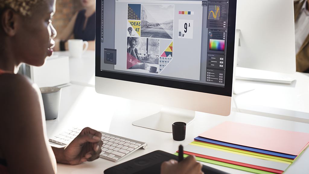 a woman uses a stylus and an art program on her computer