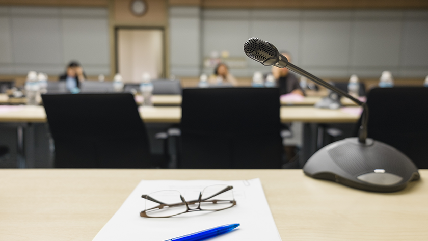 A pair of eyeglasses and a pen placed on a desk