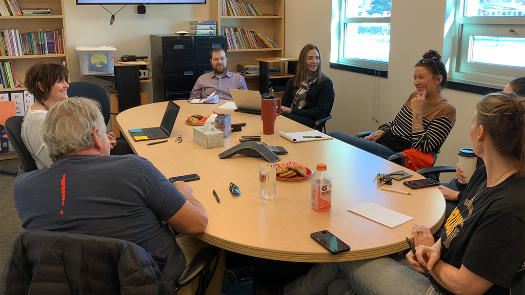 A  group of school administrators sit around a conference table.