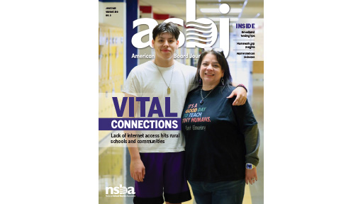 A teenage boy stands with him arm around his mother in the hallway of his school 