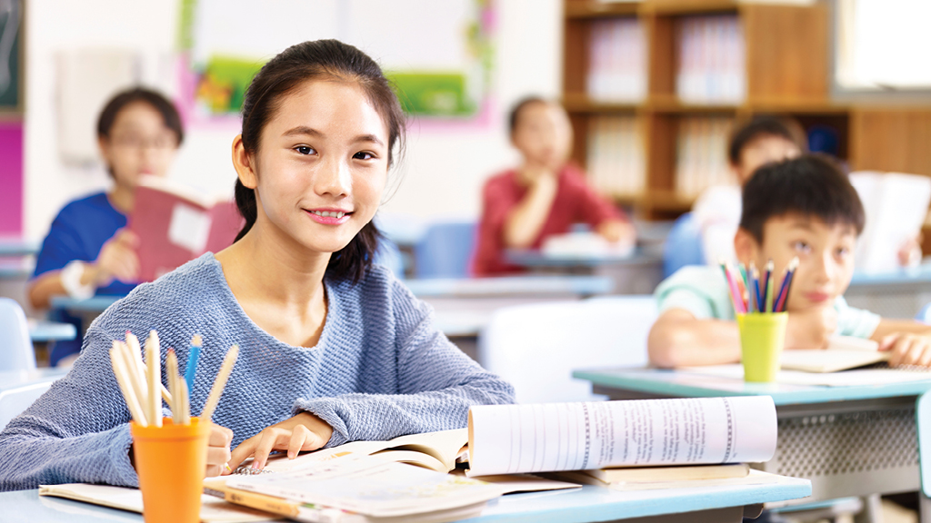 a pre-teen girl smiles at the camera. 