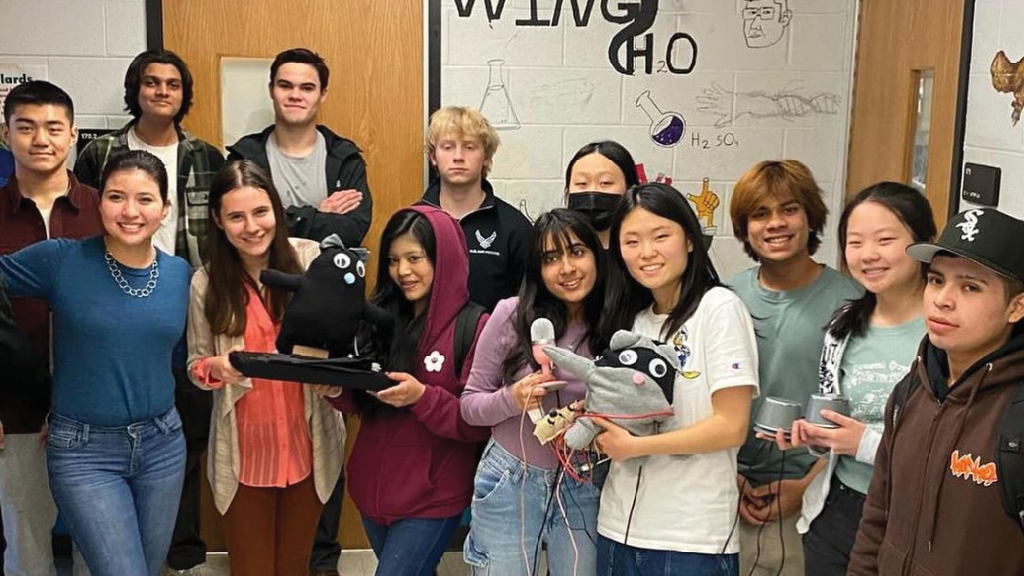 a group of 13 students show the prototypes of an artificial intelligence-powered stuffed animal that they created.